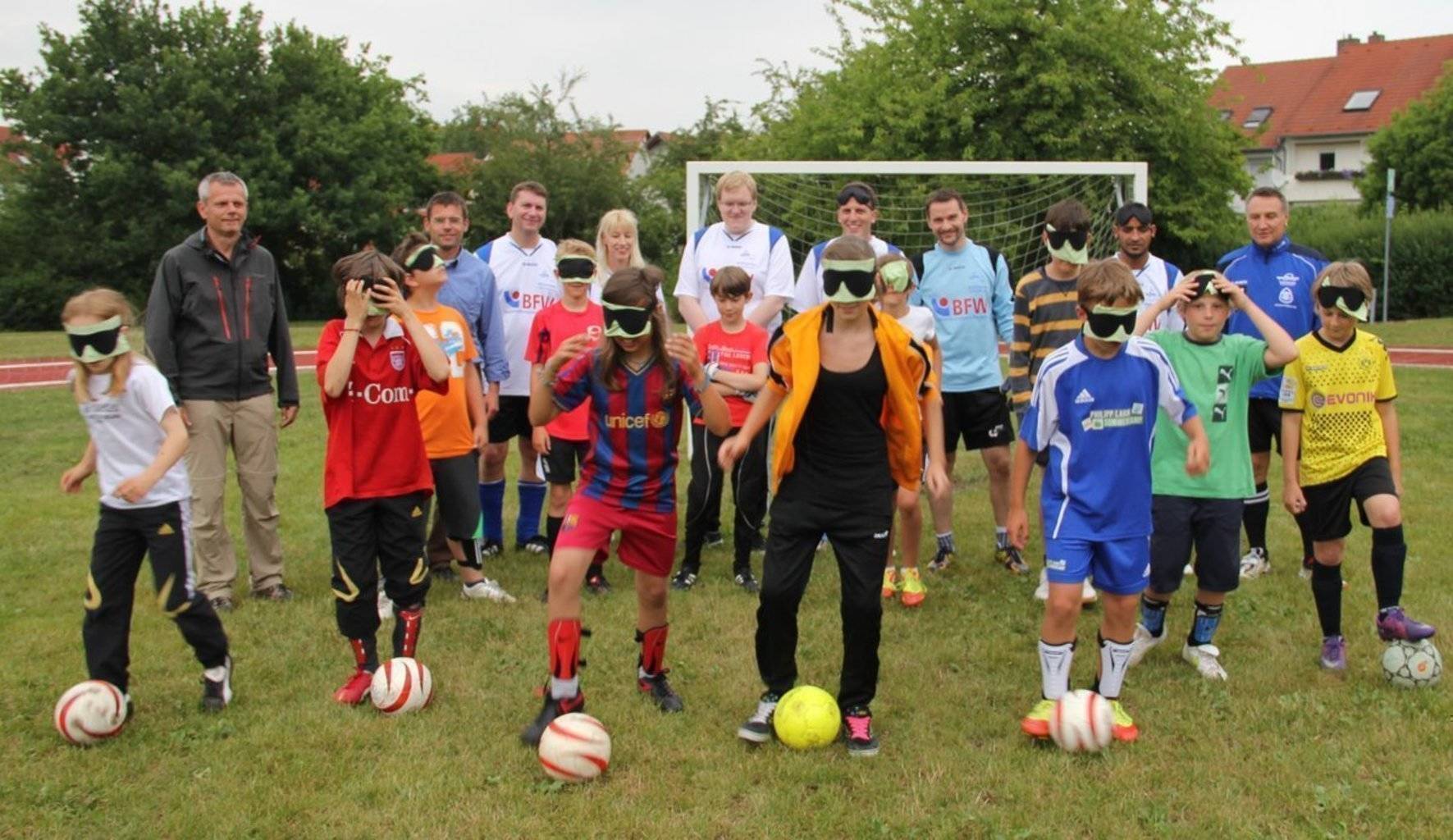 Kinder mit Dunkelbrillen versuchen Ballführung